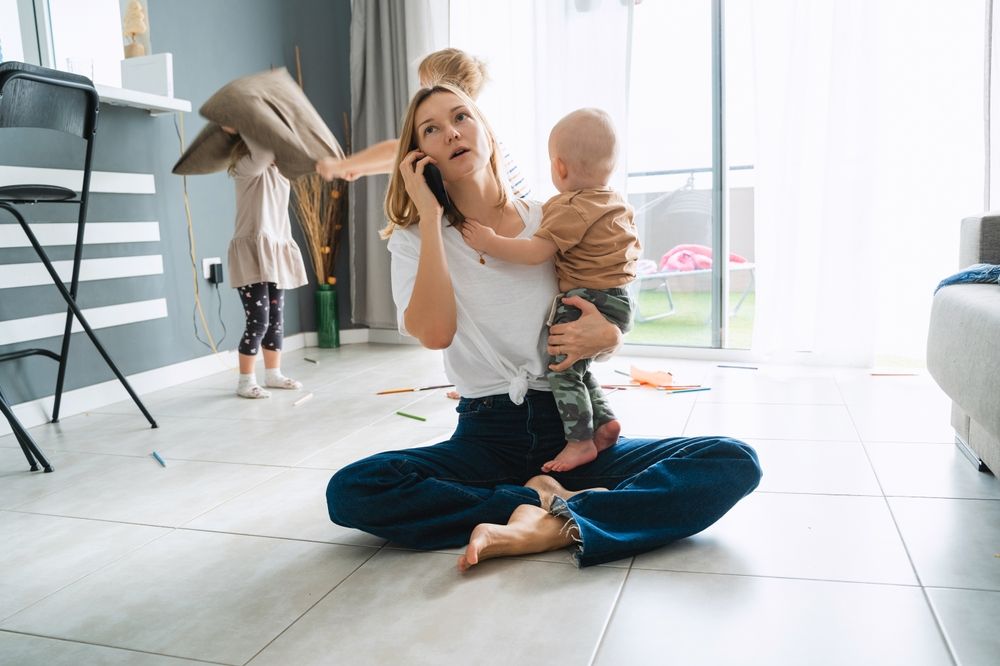Matka objímá dítě a vypadá vyčerpaně