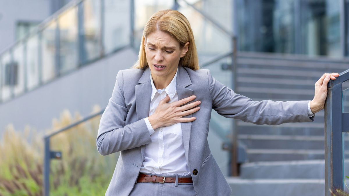 Žena drží ruku na hrudi — syndrom zlomeného srdce